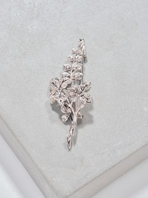 Broche en métal argenté à décor feuillagé entièrement serti …
