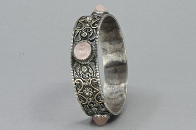 a close up of a silver ring with a pink stone in the middle