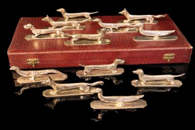 de nombreuses figurines de chiens en argent dans un coffret rouge