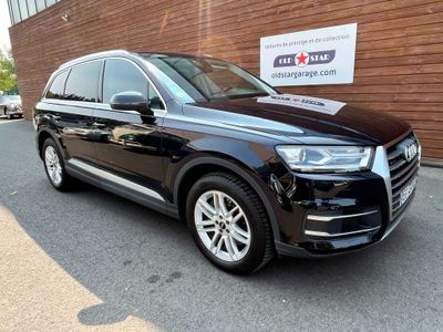 Le SUV Audi noir est garé devant un immeuble.