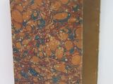an old book with a brown cover sitting on top of a table