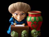a figurine of a woman sitting at a desk with a pen and a vase