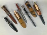 several different types of knives are lined up on a white surface