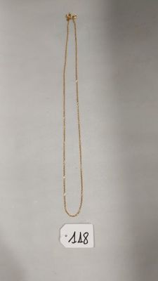 un gros plan d'un collier en or auquel est accrochée une étiquette