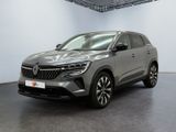 Une voiture grise est garée dans une grande pièce.