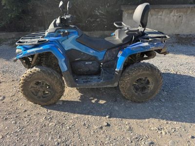 une photo d'un quad bleu garé sur un terrain en terre battue