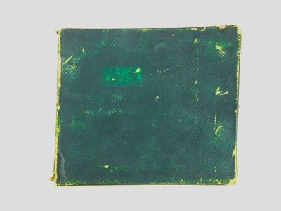 un vieux livre à la couverture verte posé sur une table