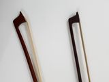 two wooden chopsticks sitting next to each other on a white surface