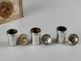 four silver cups are lined up on a table next to a picture frame
