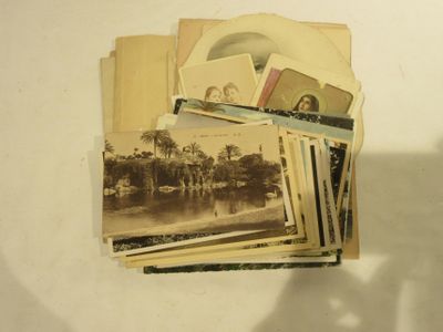 une pile de vieilles photos posée sur une table, avec l'ombre d'une personne