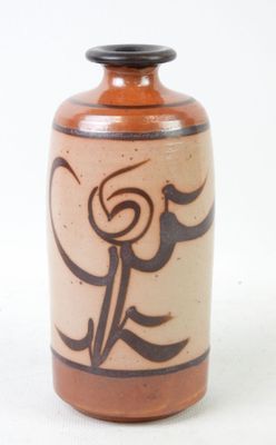 a brown vase with a design on it on a white surface