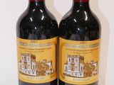 two bottles of red wine sitting next to each other on a table