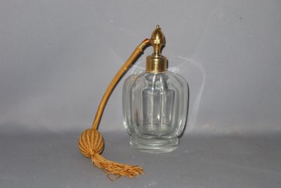 une petite bouteille en verre munie d'une poignée en bois, posée sur une table