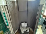 des toilettes au milieu d'une pièce dont la porte est ouverte