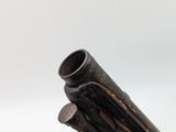 close up of a metal pipe on a white surface with a white background
