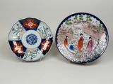 pair of japanese plates with figures and flowers on them