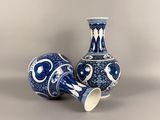 two blue and white vases sitting next to each other
