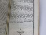 an open book on a table with a cross on it
