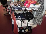 a cart with clothes and other items on it in a room