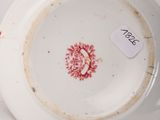 a white plate with a red flower on it
