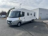 a white rv parked in a parking lot next to a building