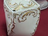 une boîte blanche et dorée posée sur une table rouge