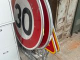 un panneau de limitation de vitesse rouge et blanc à côté d'un panneau blanc et rouge