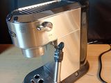 a silver coffee maker sitting on a wooden table