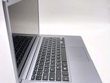 a silver laptop with a black keyboard on a white table