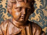 statue en bois représentant un jeune garçon tenant un oiseau dans ses mains