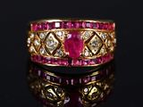 a close up of a gold ring with pink stones and diamonds