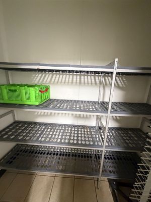 a metal shelf with baskets on it in a room