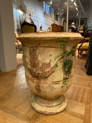 a large urn sitting on a wooden floor in a room