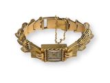 a close up of a gold bracelet with a square stone on it