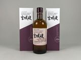 une bouteille de whisky posée sur une table à côté d'un coffret