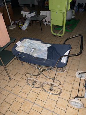 un bébé dans une poussette posée par terre dans une pièce