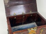 a small wooden chest with gold decorations on it