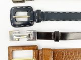 three different types of leather belts on a white surface