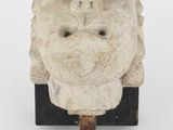un gros plan sur une sculpture représentant le visage d'un homme fixée sur un bâton