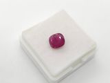 a red ruby stone on a white surface