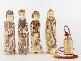 trois figurines chinoises sculptées représentant des personnages et une lanterne, posées sur un fond blanc