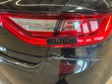 the rear end of a black car with a sticker on it