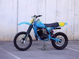 a blue dirt bike parked in a parking lot