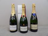 three bottles of champagne sitting next to each other on a table
