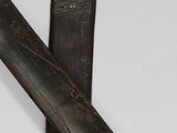 two swords that are laying next to each other on a table