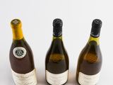 three bottles of wine sitting next to each other on a white surface