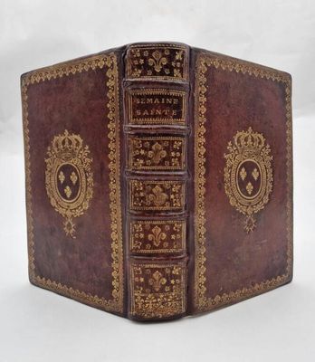 an old leather book with gold trimming and ornate design