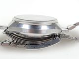 a silver watch with a chain around it on a white surface