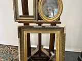three frames on a stand with a mirror on top of it