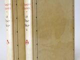 two books are sitting on a white surface with a white background